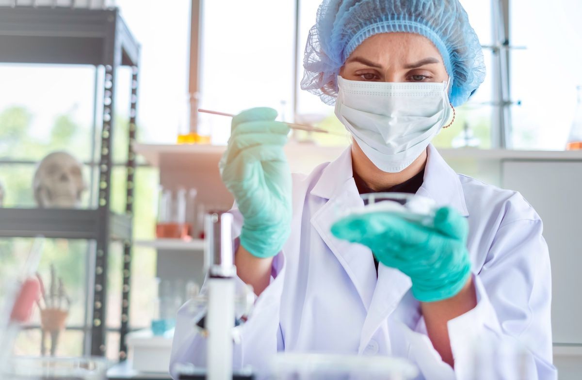 Female scientist testing experiment in a science lab where she looking to bacteria germs in agar plate. The researcher is analyzing the medicine related innovation. Microbiology concept. Copy space.